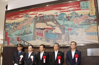 開業当時のＪＲ神戸駅付近を描いた錦絵をあしらったモニュメントを除幕した関係者ら＝神戸市中央区相生町３