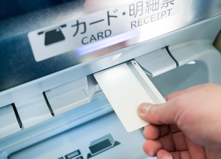 キャッシュカードで現金を引き出すイメージ（naka／stock.adobe.com）