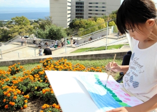 真剣な表情で海や草花を描く子ども＝淡路夢舞台