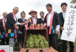 黒枝豆の販売解禁を祝う丹波篠山市の酒井隆明市長（左から４人目）や高校生、生産者たち＝７日午前、丹波篠山市郡家