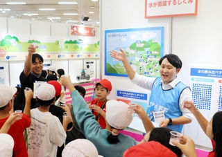 水道水とペットボトルの水を飲み比べる児童ら＝神戸市中央区港島中町６、神戸国際展示場