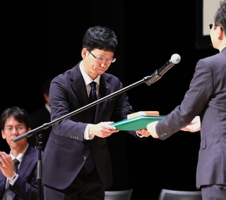 神戸新聞連載「里へ　人と自然のものがたり」が新聞協会賞を受賞し、表彰を受ける小林良多記者＝１６日午前、秋田市千秋明徳町（撮影・中西幸大）