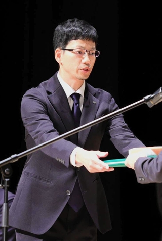 連載企画「里へ　人と自然のものがたり」が新聞協会賞を受賞し、表彰を受ける小林良多記者＝１６日午前、秋田市千秋明徳町（撮影・中西幸大）