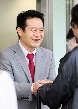 通勤客と握手して当選を報告する立民・桜井周氏＝２８日午前、ＪＲ伊丹駅前（撮影・浮田志保）