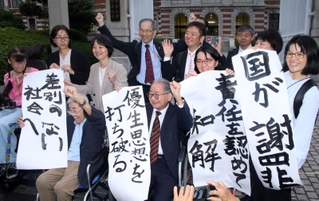 旧優生保護法下を巡る神戸地裁の３次訴訟で、原告２人が国が和解したことを報告する支援者ら＝神戸市中央区橘通２