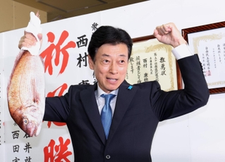 明石鯛を掲げて当選を喜ぶ西村康稔氏＝明石市樽屋町（撮影・小林良多）