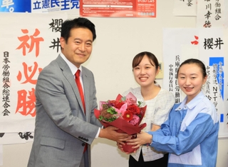 当選確実となり、支援者から花束を受け取る桜井周氏＝伊丹市西台５（撮影・吉田敦史）