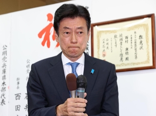 厳しい表情で支持者にあいさつする西村康稔氏＝明石市樽屋町（撮影・小林良多）
