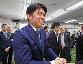 支持者と笑顔で握手を交わす中野洋昌氏＝尼崎市昭和南通７（撮影・笠原次郎）