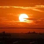 明石海峡大橋の主塔の間に落ちる太陽＝５日夕、神戸市中央区の神戸空港から（撮影・風斗雅博）