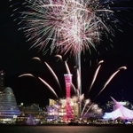 赤くライトアップされた神戸ポートタワーを背景に夜空を彩る花火＝２１日夜、神戸市中央区港島１、ポーアイしおさい公園から（撮影・大田将之）