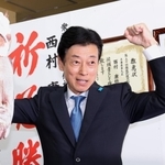 明石鯛を掲げて当選を喜ぶ西村康稔氏＝明石市樽屋町（撮影・小林良多）