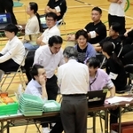 投票者数のデータ誤入力が判明し、確認作業に負われる選管職員ら＝２８日午前２時３９分、伊丹市鴻池１、伊丹スポーツセンター