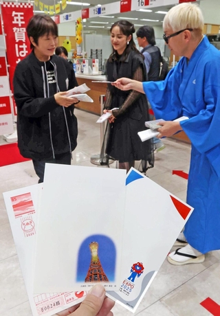年賀はがきを購入した人に記念品を手渡す平祐奈さん（中）と桂きん太郎さん（右）＝１日午前、神戸市中央区栄町通６、神戸中央郵便局（撮影・笠原次郎）