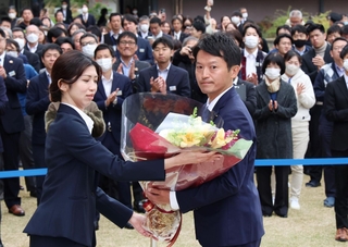 職員から花束を受け取る斎藤元彦知事（手前右）＝１９日午前、神戸市中央区、兵庫県庁（撮影・笠原次郎）