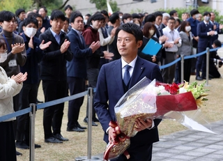 花束を手に会場を後にする斎藤元彦知事＝１９日午前、神戸市中央区、兵庫県庁（撮影・笠原次郎）