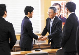 兵庫県議会各会派のあいさつ回りで、県議と握手する斎藤元彦知事（左）＝２０日午前、兵庫県議会