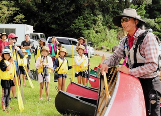 能登半島地震の被災地を訪れた木村とーるさん（右）。子どもたちにカヌーの乗り方を教えた＝９月、石川県能登町越坂（撮影・上田勇紀）
