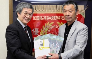 神戸新聞社の大町聡常務取締役（左）から目録などを受け取る兵庫県高野連の高橋滋理事長＝神戸市中央区古湊通２