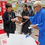 年賀はがきを購入した人に記念品を手渡す平祐奈さん（中）と桂きん太郎さん（右）＝１日午前、神戸市中央区栄町通６、神戸中央郵便局（撮影・笠原次郎）