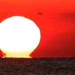 空を赤く染めながら水平線に沈んでいく「だるま夕日」＝１１日夕、神戸市垂水区から播磨灘を望む