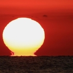 空を赤く染めながら水平線に沈んでいく「だるま夕日」＝１１日夕、神戸市垂水区から播磨灘を望む