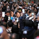 当選確実の報を受け、支持者らに囲まれながら選挙事務所に現れた斎藤元彦氏（中央）＝１７日夜、神戸市中央区