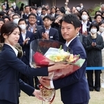 職員から花束を受け取る斎藤元彦知事（手前右）＝１９日午前、神戸市中央区、兵庫県庁（撮影・笠原次郎）