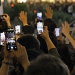 知事選の候補者に手を振り、スマートフォンを向ける聴衆＝１６日、神戸市中央区