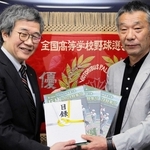 神戸新聞社の大町聡常務取締役（左）から目録などを受け取る兵庫県高野連の高橋滋理事長＝神戸市中央区古湊通２