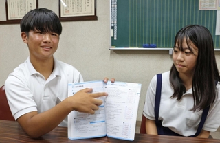 夏休みに解いた問題集を手に成果を振り返る３年の西殿蒼太郎さんと、小宮山春乃さん＝西宮市深津町、深津中学校