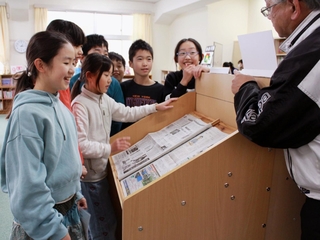 新聞閲覧台で紙面を読む子どもたち＝神戸市灘区鶴甲２、鶴甲小学校