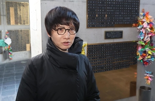 祖父の銘板を取り付けたとみさわかよのさん＝１４日午後、神戸市中央区加納町６、東遊園地（撮影・笠原次郎）