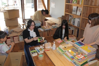 子ども用の私設図書スペースを設けるため、本の整理をする住民たち＝丹波市青垣町佐治、本町の家