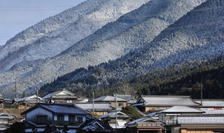 降り積もった雪で真っ白になった山沿いの集落＝１９日午前、兵庫県神河町大山