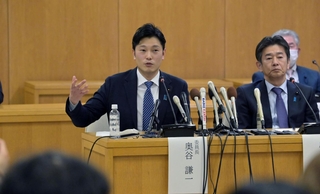 記者の質問に答える奥谷謙一委員長（左）＝２５日夜、神戸市中央区