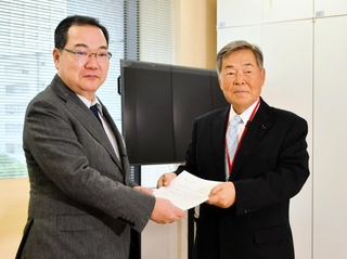 総務省の担当者に意見書を手渡す兵庫県議会の浜田知昭議長（右）＝東京都千代田区