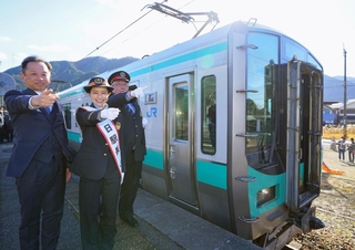 加古川線の全線開業１００周年を祝う谷川駅の一日駅長を務めた斉藤雪乃さん（中央）ら＝２７日午後、ＪＲ谷川駅
