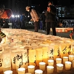 今年１月１７日のつどいで紙灯籠に火をともす人たち＝神戸市中央区加納町６