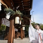 新年に向け、ささぼうきですすを払う巫女＝１３日午前、神戸市中央区多聞通３、湊川神社（撮影・大田将之）