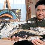 レインボーハウスに届けられた「黒い虹」の絵の一部を持つ職員。左奥は制作当時を再現したレプリカ＝２４日午前、神戸市東灘区本庄町１（撮影・風斗雅博）