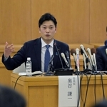 記者の質問に答える奥谷謙一委員長（左）＝２５日夜、神戸市中央区