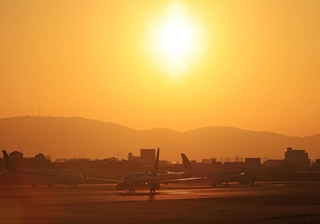 生駒山から昇る太陽を背にＢ滑走路を走る飛行機＝１日午前７時２６分、伊丹市森本７、伊丹スカイパーク