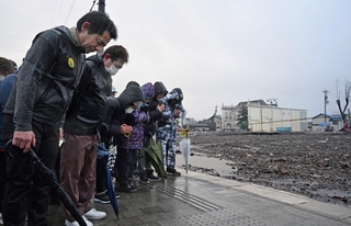 地震の発生時刻に合わせて黙祷する輪島市朝市組合の組合員ら＝１日午後４時１０分、石川県輪島市河井町（撮影・風斗雅博）
