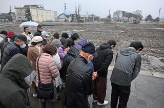 地震の発生時刻に合わせて黙祷する輪島市朝市組合の組合員ら＝１日午後４時１０分、石川県輪島市河井町（撮影・風斗雅博）