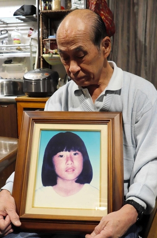 紗綾香さんの遺影を抱く田村稔さん＝神戸市灘区浜田町
