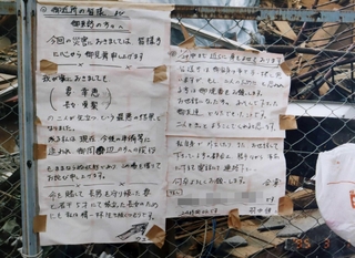 全壊した自宅前に張ったメッセージ。「精一杯生き抜く」と書いた＝１９９５年３月、西宮市甲東園３（羽中健二さん提供、画像の一部を加工しています）