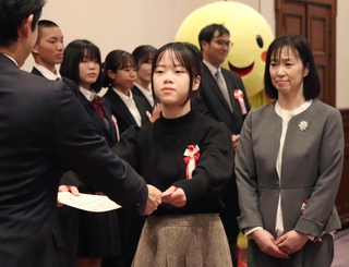 グランプリに選ばれ、表彰状を受け取る宮城県岩沼市立玉浦小の佐藤音々さん（中央）＝兵庫県公館