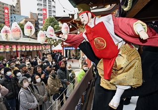 淡路人形浄瑠璃の奉納で、大勢の参拝者を前に福を振りまくえびす様＝９日午後、神戸市兵庫区西柳原町（撮影・風斗雅博）