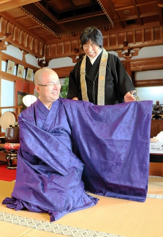 父が残した衣を着る冨永龍弘さん。母の明子さんも笑顔を見せる＝神戸市須磨区須磨寺町４
